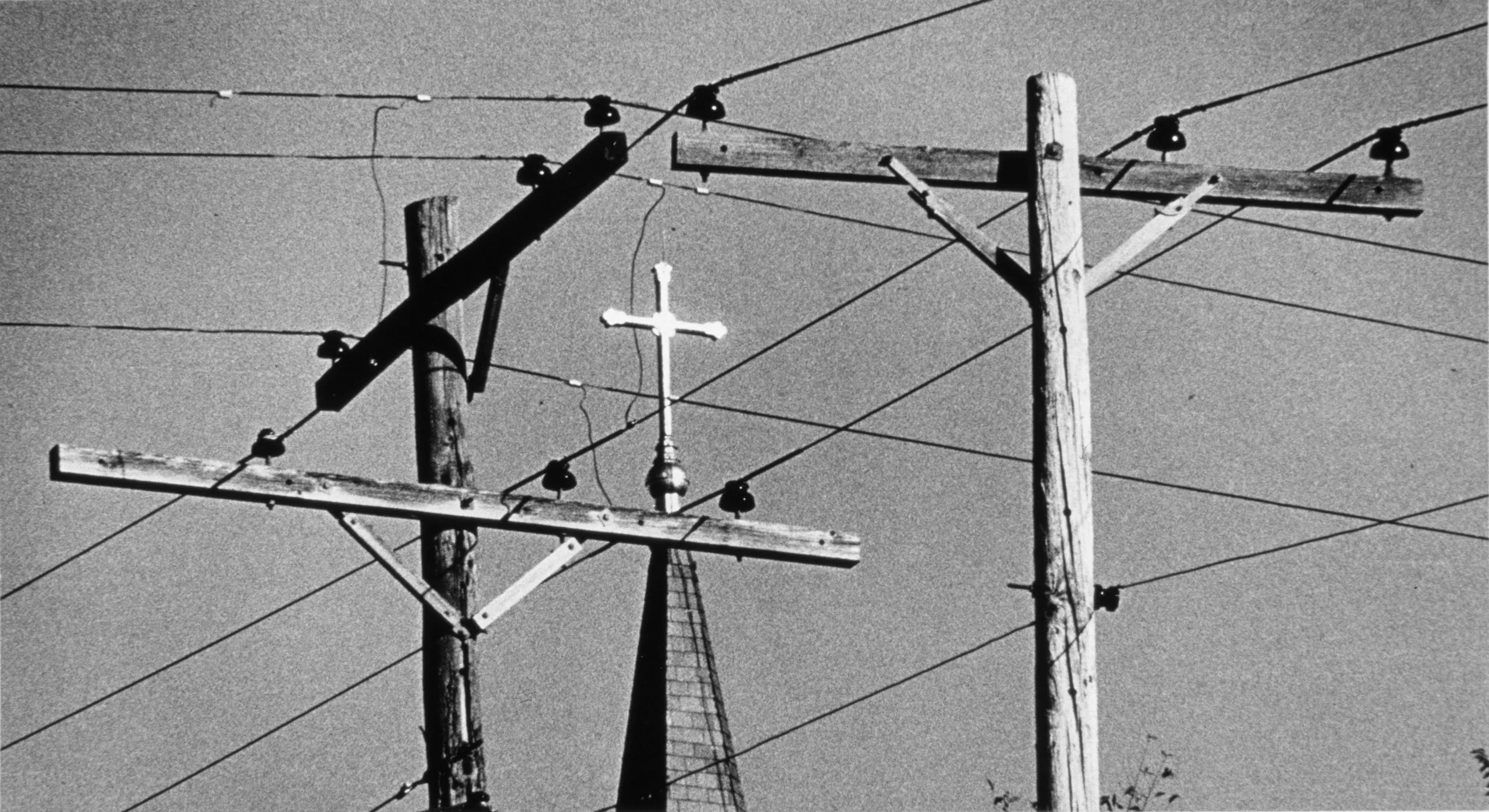 Catholicism in Glasgow, Missouri — A gold toned cross atop the steeple of Saint Mary's Catholic Church, built high above the Missouri River in Glasgow, Missouri, radiates in the Sunday morning sunlight as Mass is being celebrated. The image was published as the "Religion" section front photograph in "Glasgow - Story of a Missouri Rivertown," a book published by the Missouri School of Journalism in 1979.  (Photo by Stephan Savoia)