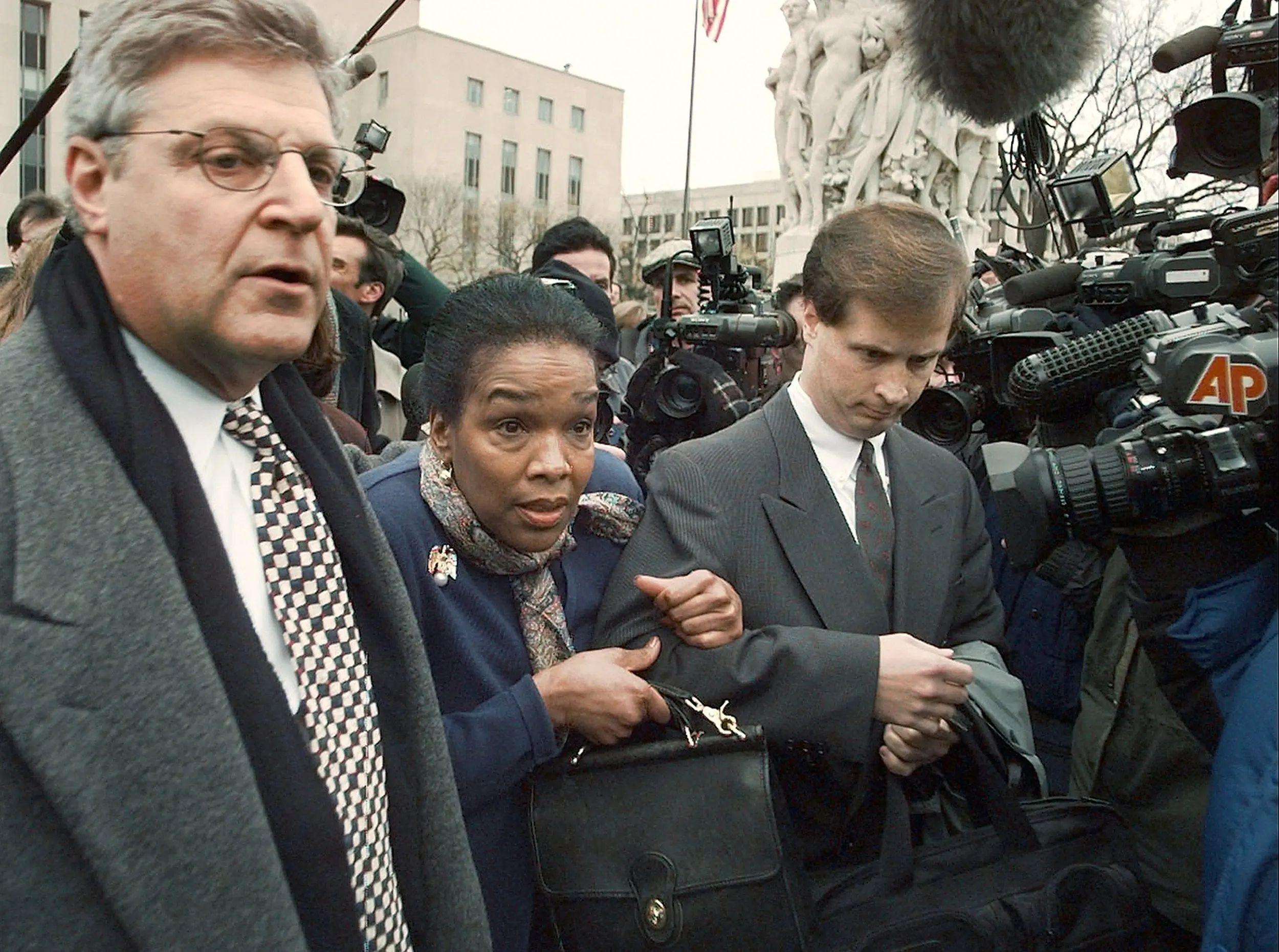 Trapped — President Bill Clinton's personal secretary, Betty Currie, clutches her purse as she and her attorney Lawrence Wechsler, left, work their way through a crush of media outside the United States Federal Courthouse in Washington, D.C., Tuesday January 27, 1998. Currie appeared before a grand jury that is looking into charges concerning President Clinton's and former White House intern Monica Lewinsky's sex scandal.  (AP Photo/Stephan Savoia)  © The Associated Press