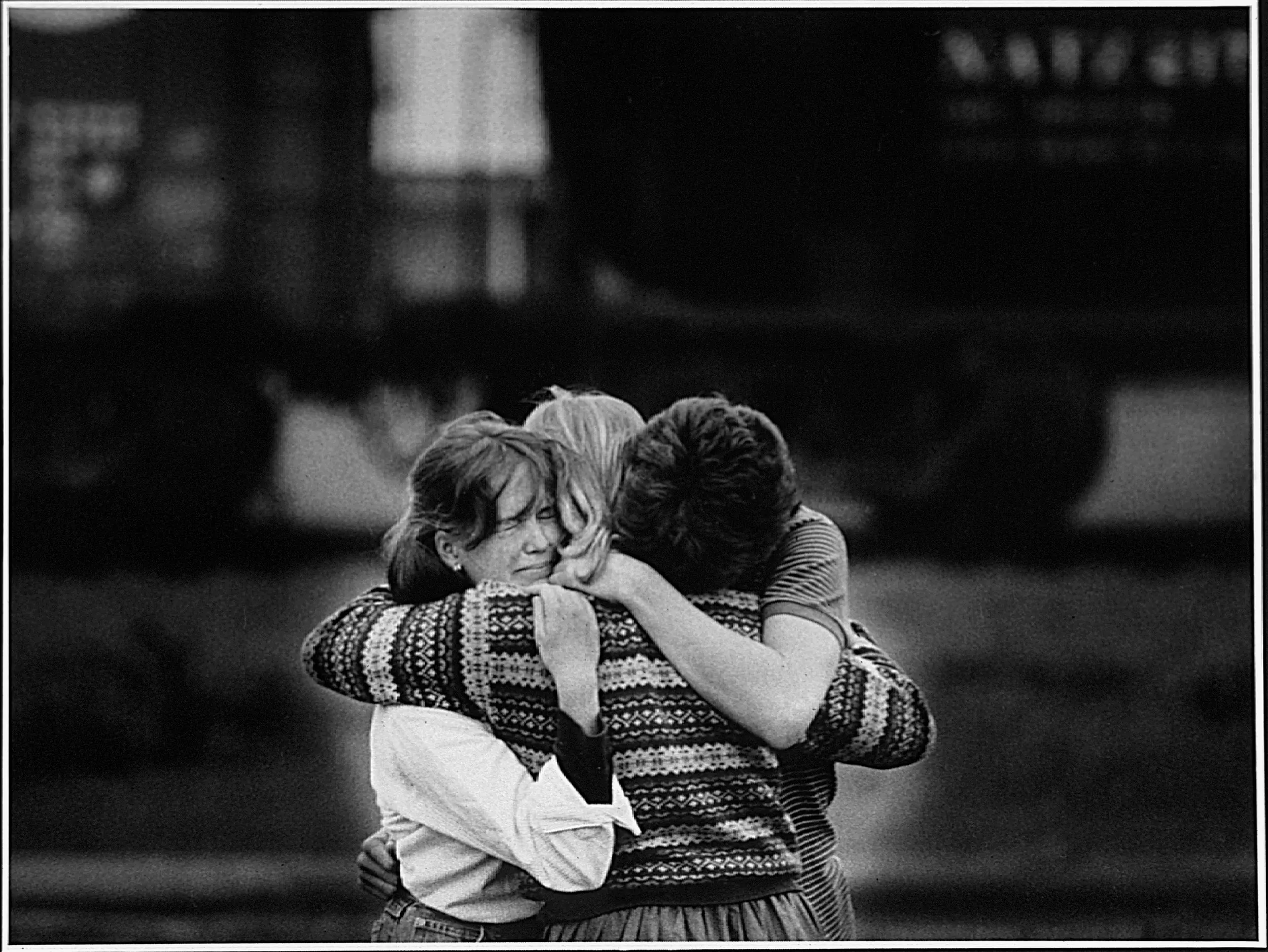 The Heartache Of Hurry — Three high school students, who chose not to give their names, mourn the death of a friend as they huddle together alongside a freight train that ran into a classmate's car while their friend was attempting to beat the train through its crossing the day before Thanksgiving in Monroe, Louisiana.  (Photo by Stephan Savoia)  Published by The Monroe Louisiana New-Star-World Circa Early 1980s