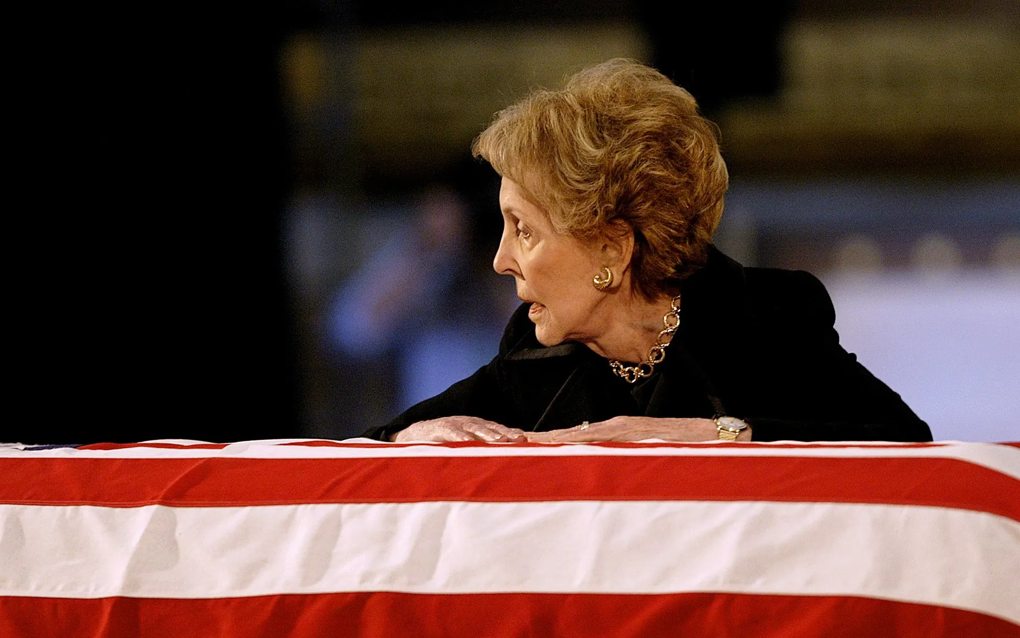 Goodby Ronnie — Former first lady Nancy Reagan talks to her husband, President Ronald Reagan, as she leans over his flag-draped casket shortly before his body was removed from the Rotunda of the U.S. Capitol in Washington, D.C., on Friday morning, June 11, 2004.  (AP Photo/Stephan Savoia)  © The Associated Press